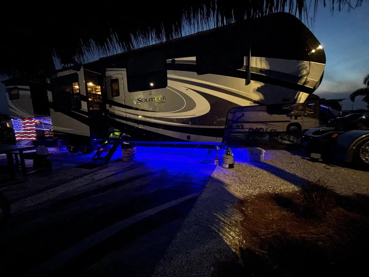 Travel trailer with blue underglow at dusk in Florida