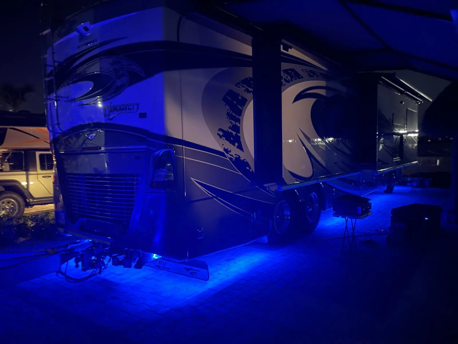 Motorhome at night with vivid blue RGBW LED underglow lighting the pavement